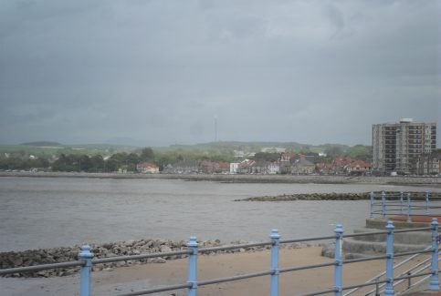 View of the sea and Bare sea front from the promenade at Morecambe, showing Princes Crescent flats far right.