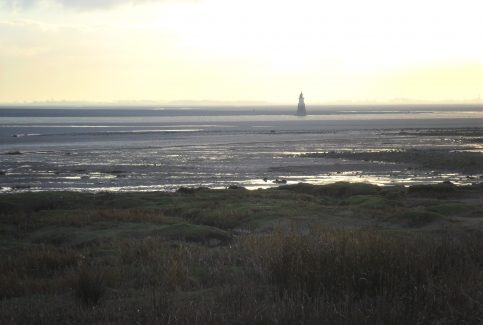 Plover Scar lighthouse seen from Sunderland Point at dusk.