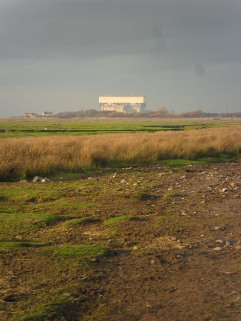 View of the shore at low tide to the west of Sunderland Point, with Heysham nuclear power station in the distance.